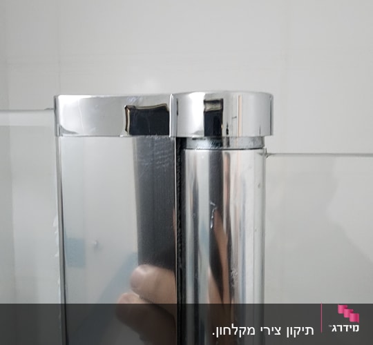 דלת זכוכית עם מסגרת מתכת בחדר אמבטיה